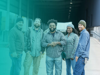 A group of guys standing on the street looking happy