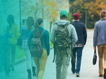 A group of teens walking away on the sidewalk