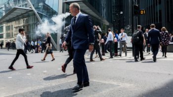 Man walking across a busy street and vaping. Learn more about vaping and tobacco prevention in Colorado.
