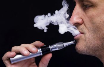 A man using a vape device. Learn more about vaping and the risks.