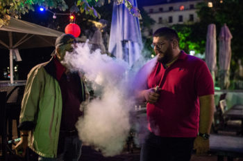 Two men use vape devices. Learn more about vaping and the risks.