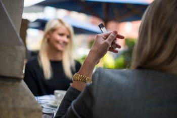 Woman using a JUUL e-cigarette. Learn more about vaping and the risks.