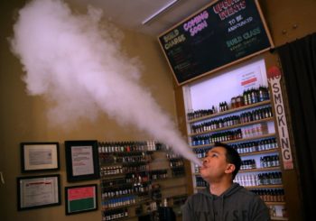 Man using an e-cigarette. Learn more about vaping and the risks.