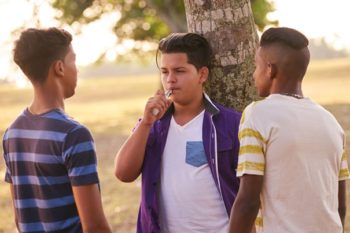 Teens use a vape device in this stock image. Learn more about vaping and tobacco use in Colorado.