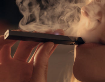 Colorado adult uses a vape pen in this stock image. Learn more about vaping and tobacco use in Colorado.