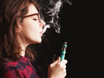 Colorado adult uses a vape pen in this stock image. Learn more about vaping and tobacco use in Colorado.