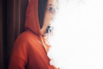 Colorado adult uses a vape pen in this stock image. Learn more about vaping and tobacco use in Colorado.