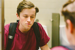 Depressed teen student helplessly stares at his reflection in bathroom mirror. Learn more about vaping and tobacco prevention in Colorado.