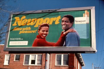 Image of a billboard displaying a Newport menthol cigarette advertisement that features a smiling African American couple embracing.