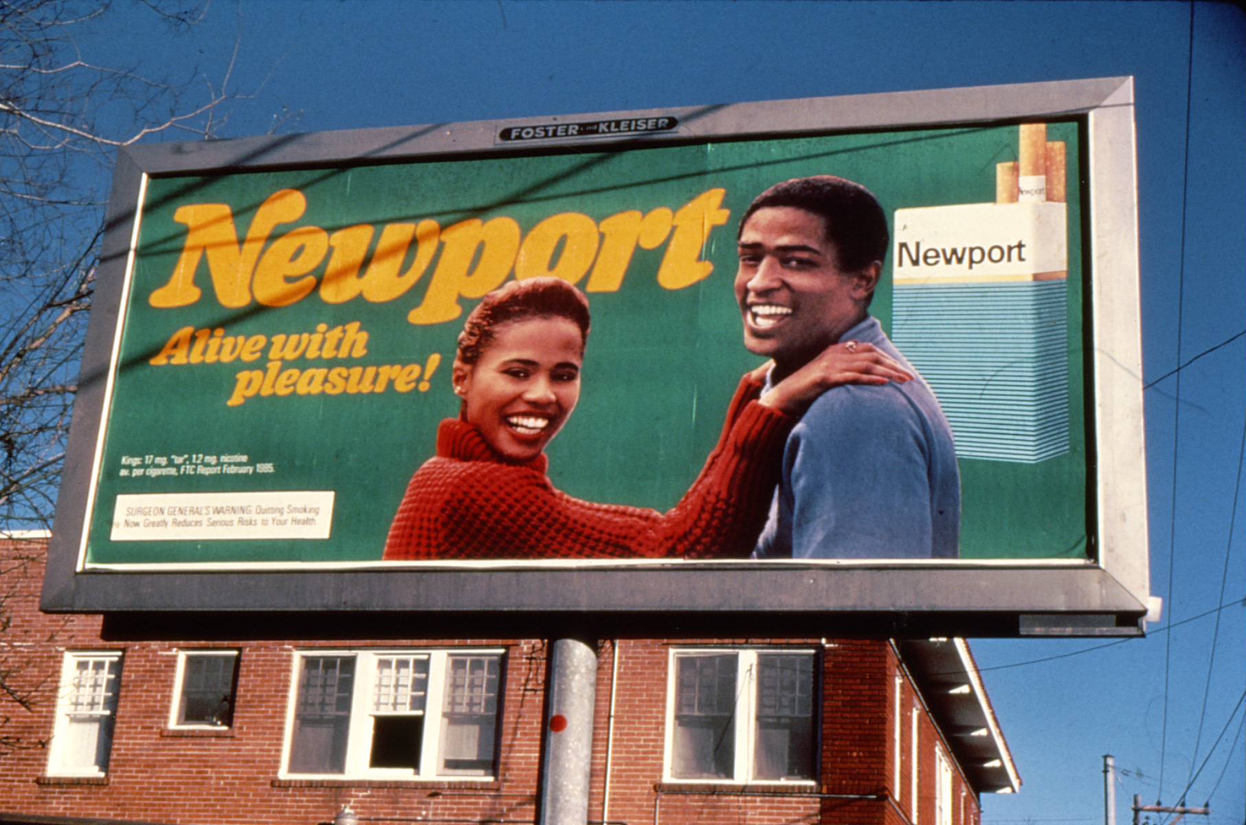 Image of a billboard displaying a Newport menthol cigarette advertisement that features a smiling African American couple embracing.